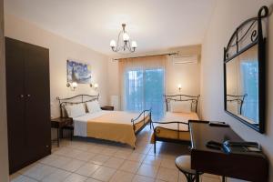 a hotel room with two beds and a mirror at Kipos Resort in Nea Peramos
