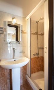 a bathroom with a sink and a shower at Kipos Resort in Nea Peramos