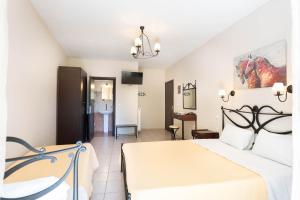 a bedroom with a bed and a living room at Kipos Resort in Nea Peramos