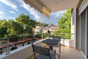 a balcony with a table and chairs and a view at Kipos Resort in Nea Peramos