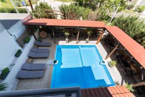 an overhead view of a pool with chairs and a house at Kipos Resort in Nea Peramos