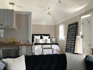 a bedroom with a bed and a kitchen with a couch at The Bakers Cottage in Armidale +3 photos