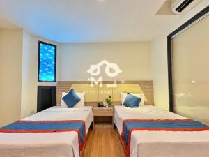 a room with two beds and a desk at Domoi Family Hotel & Apartment in Nha Trang +53 photos