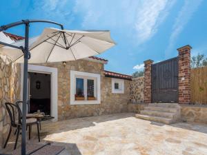 a patio with a table and an umbrella at Holiday Home Rider - Two Bedroom Holiday Home with Outdoor Pool in Vrpolje