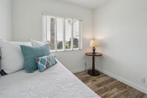 a bedroom with a bed with a lamp and a window at Beautiful 2 Bed Beach Condo #203 in Carpinteria +18 photos
