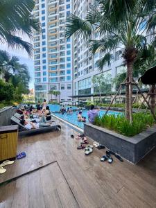 a group of people sitting around a swimming pool at Khánh Phong Apartment Premire Sapphire Hòn Gai Hạ Long in Ha Long