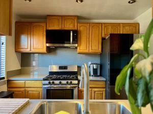 a kitchen with wooden cabinets and a stove top oven at By Popular Demand - Richmond in Richmond