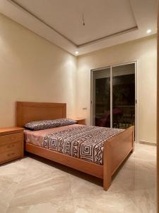 Un dormitorio con una cama y una ventana grande. en Appartement Cosy Bouznika, plage proche, en Bouznika 11 fotos más