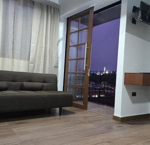 a living room with a couch and a sliding glass door at Hotel del Tren Boutique in Alausí