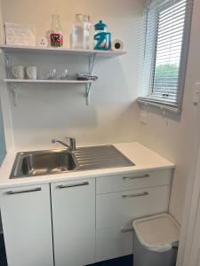 a small white kitchen with a sink and a toilet at Matua Studio in Tauranga