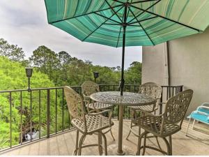 a table with chairs and an umbrella on a balcony at Luxury Penthouse near Beach Tiki Hut Coligny in Hilton Head Island