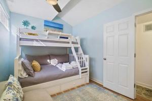a bedroom with a bunk bed with a ladder at Luxury Penthouse near Beach Tiki Hut Coligny in Hilton Head Island