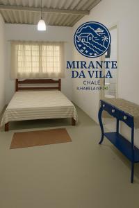 a bedroom with a bed and a sign on the wall at Aluga se Casa Chalé no MIRANTE DA VILA com VISTA INCRÍVEL in Ilhabela
