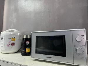 a kitchen counter with a microwave and a food processor at Narathiwat homestay rumah kelabu in Ban Kam Pong Ba Ru