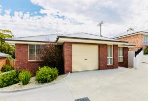 a brick house with a garage at Blackmans Bay Villa in Kingston Beach