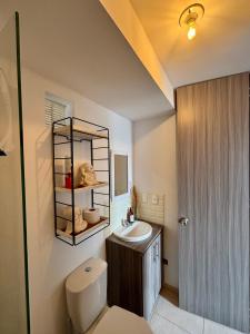 un baño con inodoro y lavabo en Casa del ocaso con parking, en Armenia
