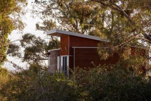 a small house on top of a hill with trees at Eco-Luxe @ Mount Avoca in Avoca