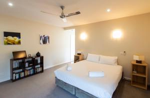 a bedroom with a large white bed and a tv at Eco-Luxe @ Mount Avoca in Avoca