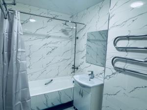 Un baño blanco con lavabo y espejo. en COZY Apartment in Bukhara !, en Bukhara 9 fotos más