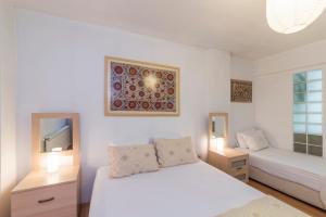 Habitación blanca con 2 camas y TV. en Istanbul Amedros Home, en Estambul