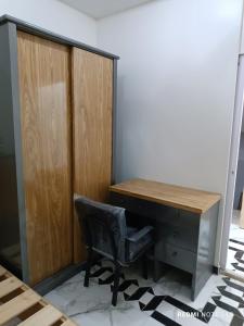 a desk with a chair next to a wooden cabinet at شقق فندقية تشطيب سوبر لوكس in Mît Khamîs