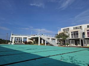 a tennis court in front of a building at Hazuma Homestay in Tawangmangu