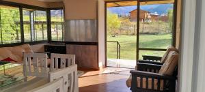 a living room with a table and chairs and a large window at El Contenedor in Tunuyán