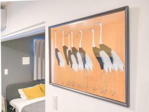 a framed picture of flamingos hanging on a wall at Triphome Asakusa Alpha 3min to Sensoji Temple in Tokyo +28 photos