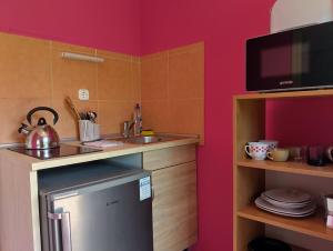 a small kitchen with a sink and a microwave at Apartman a Déliparton in Szántód