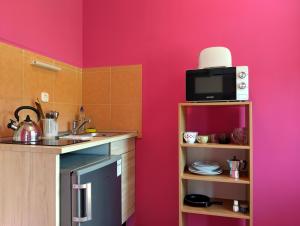 a kitchen with a sink and a microwave at Apartman a Déliparton in Szántód +7 photos
