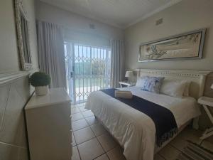 una camera da letto con un letto e una grande finestra di Clifton Cottage a Kei Mouth