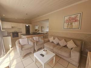 un soggiorno con divano e sedie e una cucina di Clifton Cottage a Kei Mouth