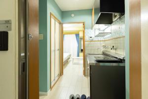 a kitchen with green walls and a sink and a tub at Mary's Maison Repos in Fukuoka