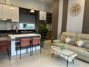 a kitchen and living room with a couch and a clock at Chao Pao Villa Phase 2 in Ko Phangan