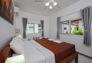 a white bedroom with a bed and a window at V201 1BR Pool Access Walk to Yanui Beach in Nai Harn Beach +54 photos