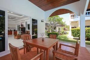 a dining room and living room with a wooden table and chairs at V201 1BR Pool Access Walk to Yanui Beach in Nai Harn Beach