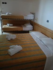 two beds in a room with white towels on them at Hotel sidney in Bellaria-Igea Marina