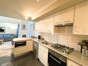 a kitchen with a sink and a stove top oven at Bay Village Dunsborough in Dunsborough