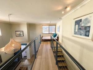 a room with a staircase with a couch and a window at Bay Village Dunsborough in Dunsborough