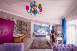 a living room with purple furniture and a chandelier at Limnades Hotel İznik in İznik