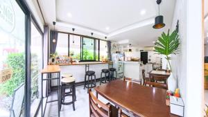 a room with a bar and a kitchen with windows at Gusto House in Chiang Mai