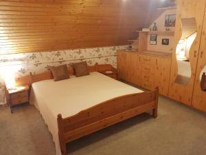 Un dormitorio con una cama en una habitación de madera. en István Ház, en Balatonkeresztúr