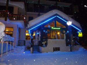 Un bâtiment avec des lumières bleues dans la neige dans l'établissement Hôtel Le Grand-Bec, à Pralognan-la-Vanoise