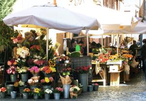 an outdoor flower market with flowers in buckets at Mario De' Fiori 37 in Rome