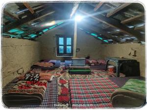 Habitación con varias camas en una habitación con techo. en Odin's Garden Cafe and Cottage, Kalga Kasol, en Kulu