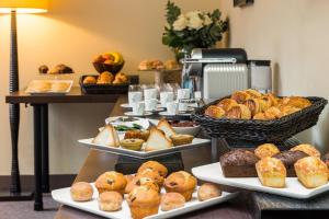 a table with several plates of pastries and breads at Hôtel La Bourdonnais by Inwood Hotels in Paris +37 photos