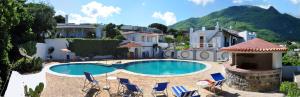 a swimming pool with chairs and a house at Hotel Residence Villa Teresa in Casamicciola Terme