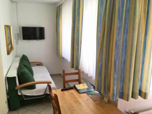 ein Wohnzimmer mit einem Bett, einem Tisch und einem Sofa in der Unterkunft AJO Apartments - Alte Donau Garden Flat - Self-Check-in in Wien