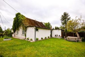 a white house with a grass yard at Sobieszewska Ostoja in Gdańsk