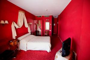 een rode slaapkamer met een bed en een televisie bij Sylva Hotel in Limassol